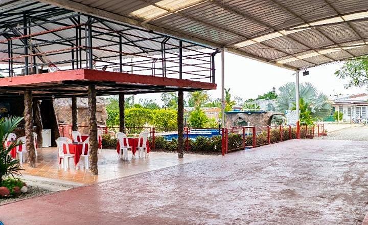 Comedor de la sede campestre, con mesas bajo techo junto a la piscina